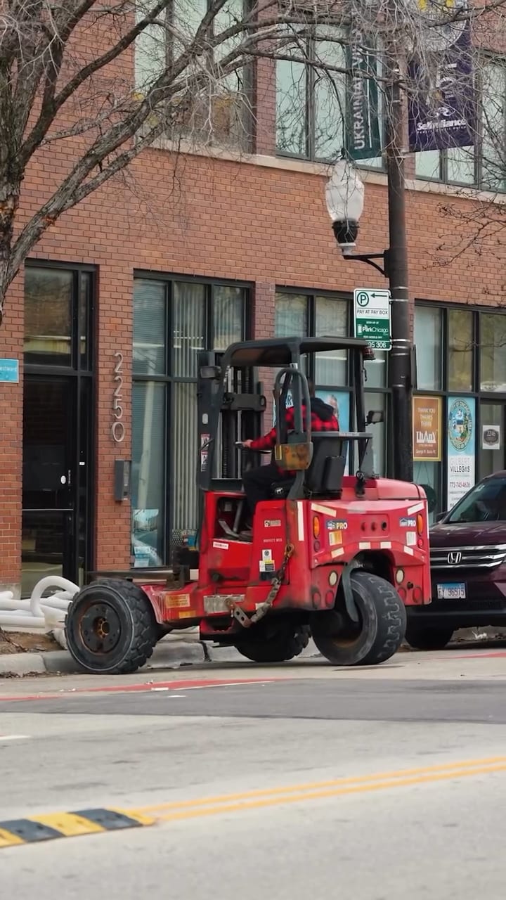 Forklift unloading drywall on a Chicago street