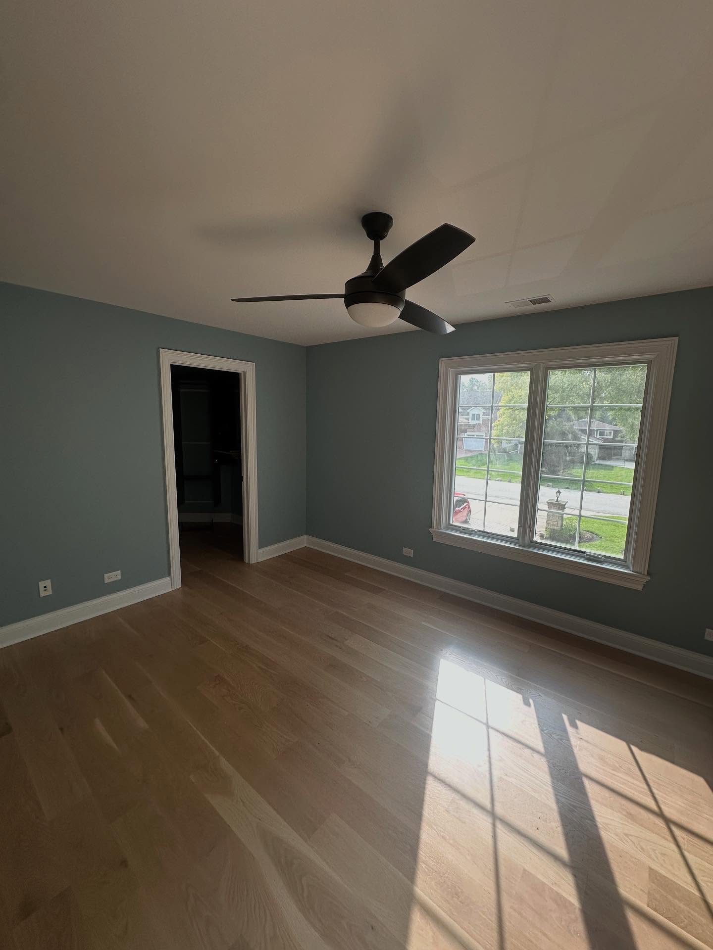 Freshly painted blue bedroom with natural light and clean trim work