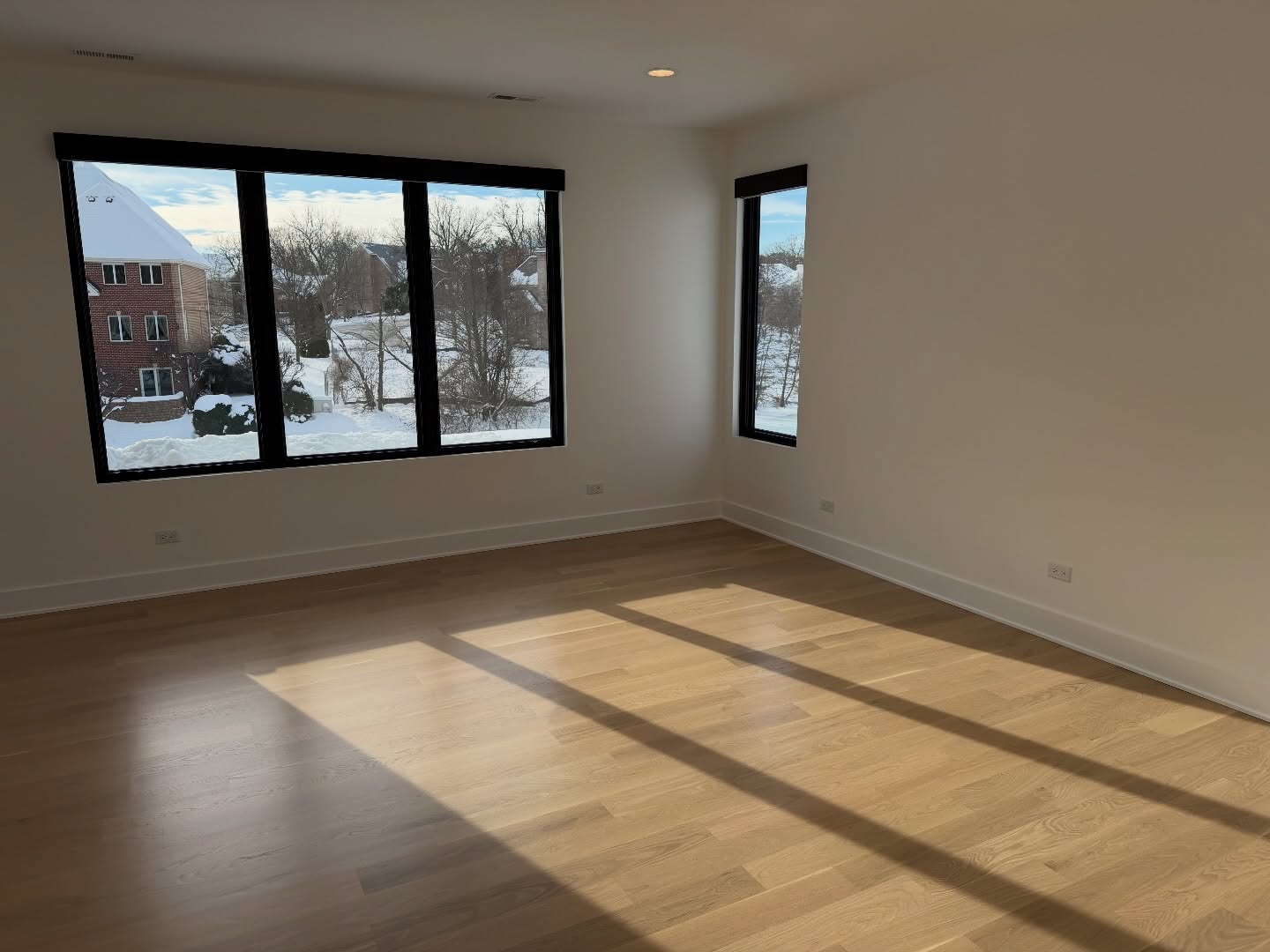 Sunlit bedroom with pristine walls and large windows in Burr Ridge