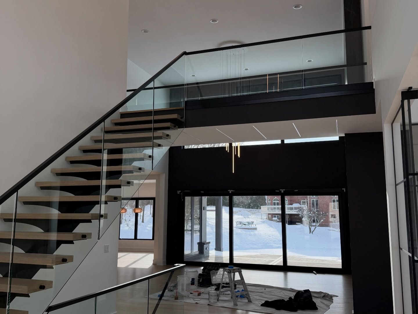 Modern open-concept with floating staircase and glass railing
