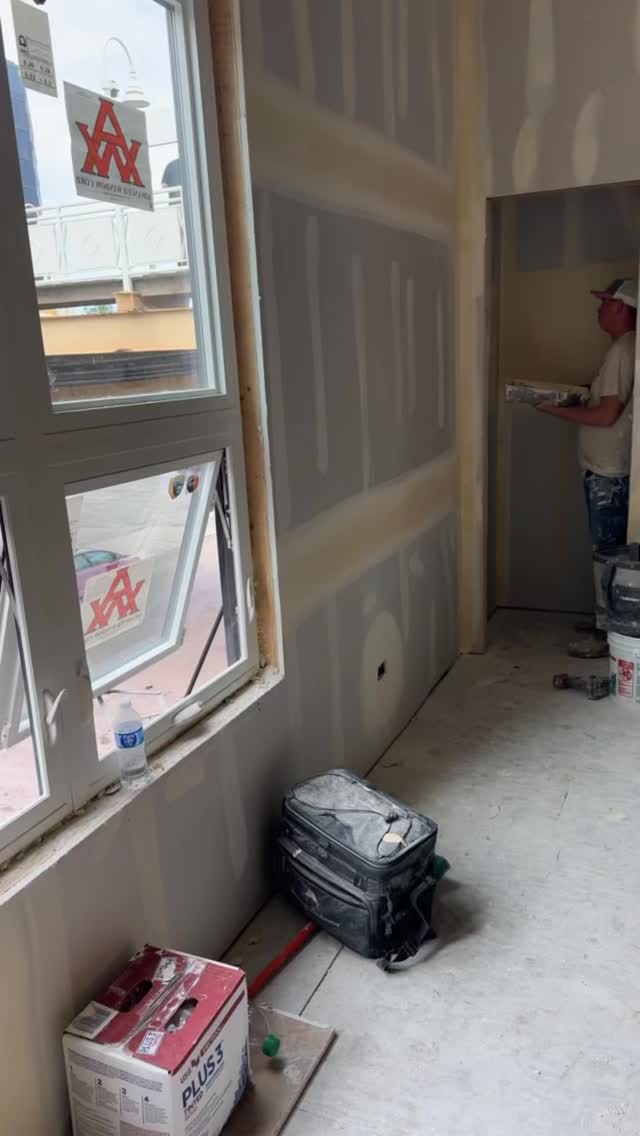Worker applying mud at commercial taping job