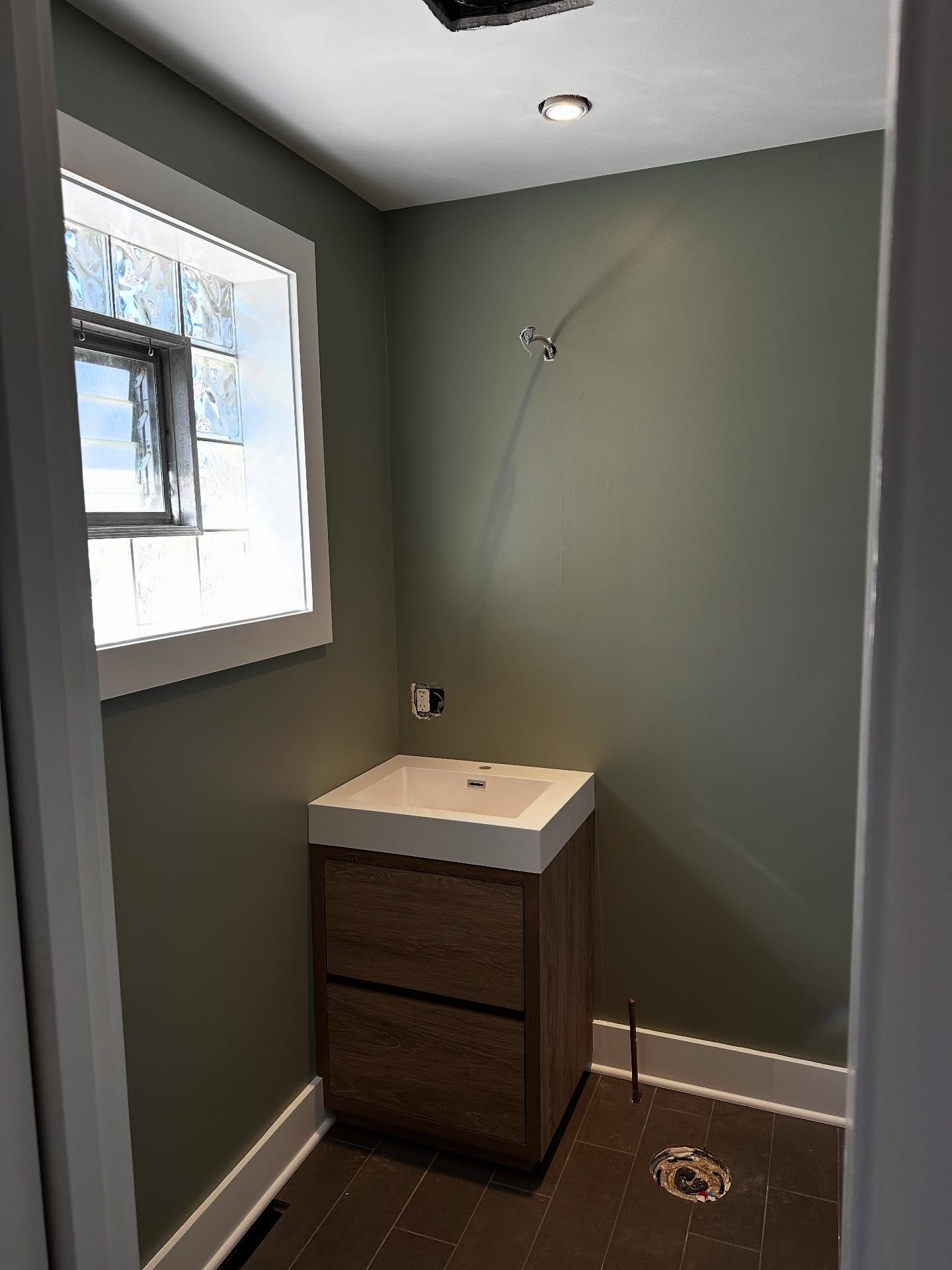 Finished sage green bathroom remodel with wooden vanity