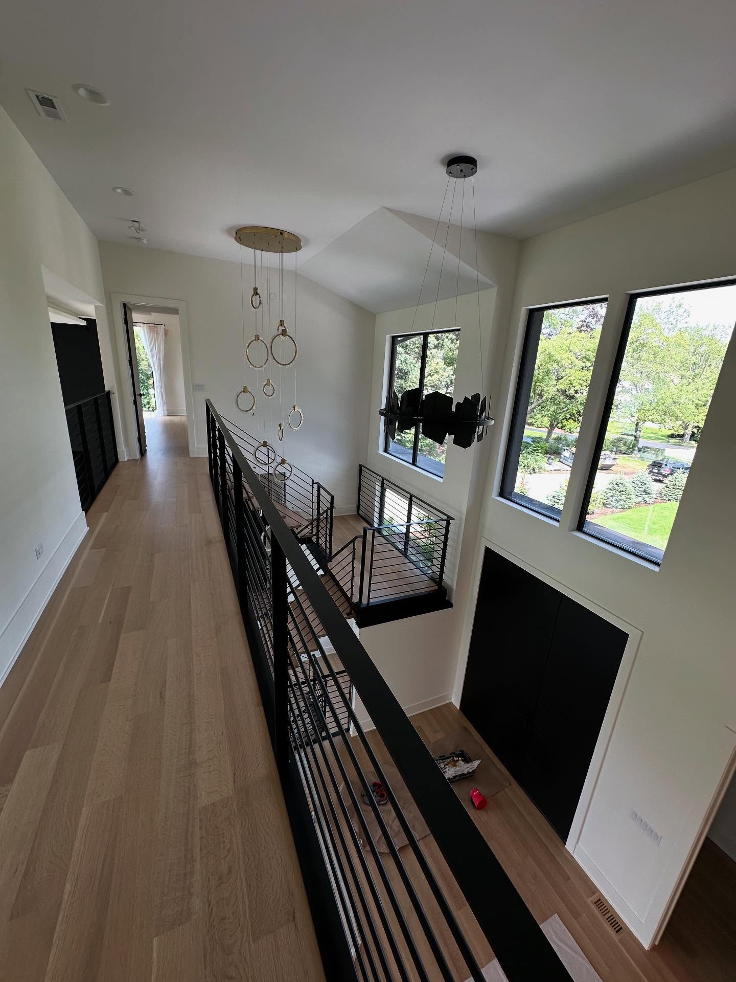 Upper hallway overlooking a dramatic stairwell in a custom home