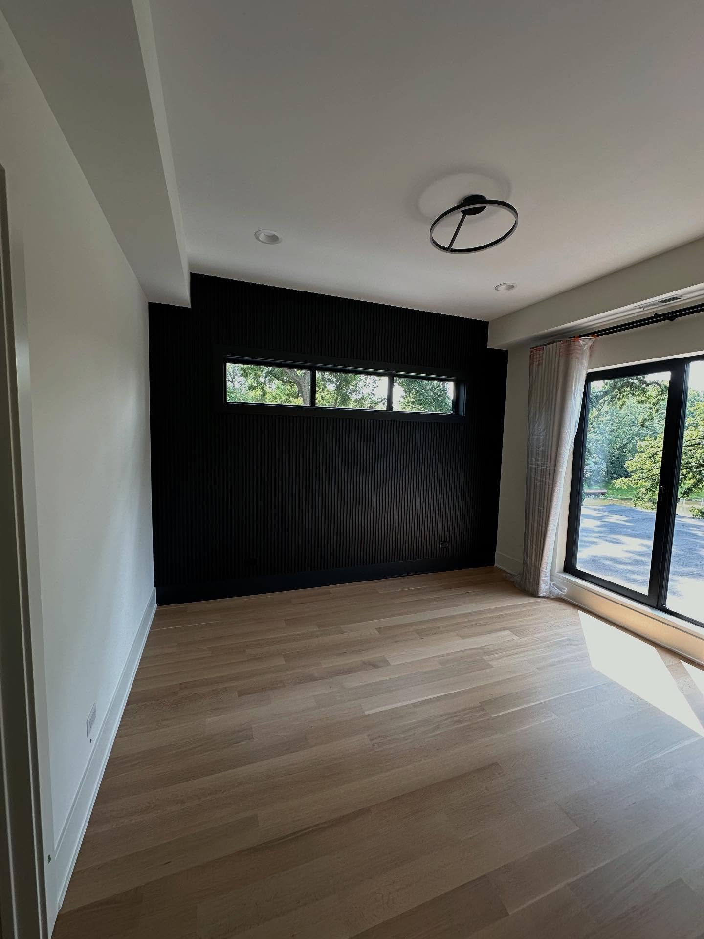 Bedroom with black slatted accent wall and modern ring light