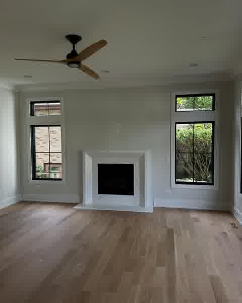 Freshly painted living room with marble fireplace and hardwood floors
